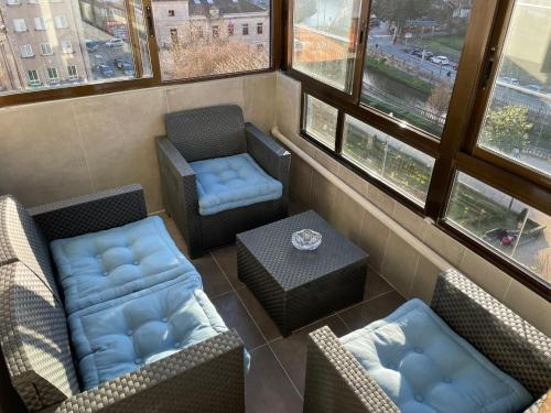 a room with two chairs and a table and windows at Alojamiento Alameda in Redondela