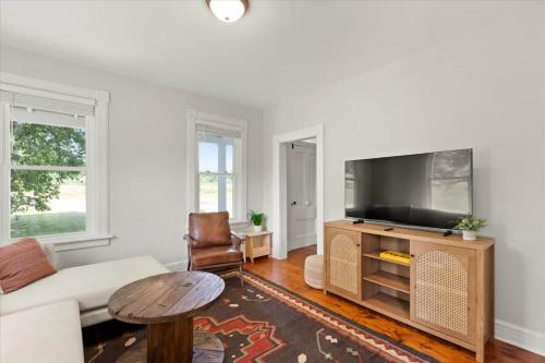 a living room with a couch and a flat screen tv at Hudson Restored Farmhouse with Fire Pit in Hudson