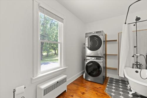 a bathroom with a washing machine and a sink at Hudson Restored Farmhouse with Fire Pit in Hudson