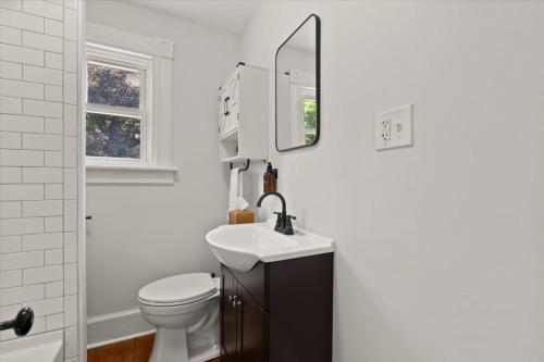 a bathroom with a sink and a toilet and a mirror at Hudson Restored Farmhouse with Fire Pit in Hudson