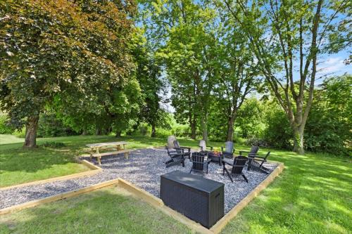 a backyard with chairs and a table and a tv at Hudson Restored Farmhouse with Fire Pit in Hudson