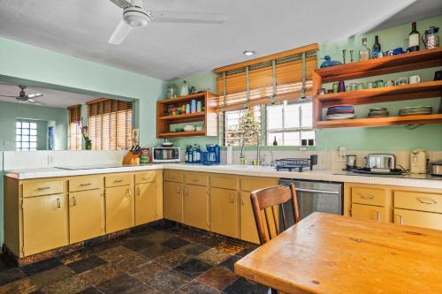 a kitchen with yellow cabinets and a wooden table at Steps to Venice Beach Vintage Venice Retreat in Los Angeles