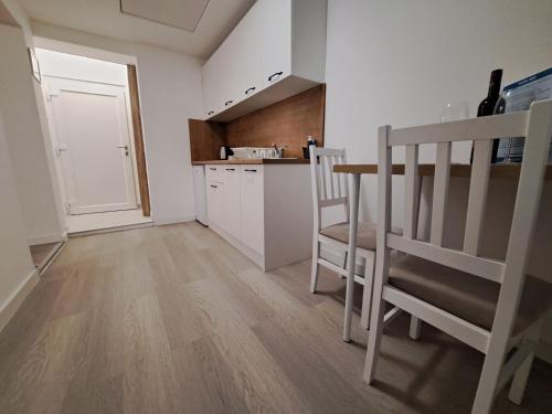 a kitchen with a table and chairs in a room at Apartments Orlić - Self check-in with code, WI-FI, Netflix, smart TV, garden in Zagreb