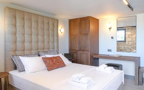 a bedroom with a large white bed and a fireplace at Sitovolonas Superior Accommodation in Nafplio