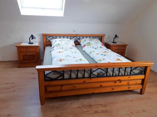 a bedroom with a wooden bed with two night stands at Landhaus Grimburg - Ferienwohnung Obergeschoss in Grimburg