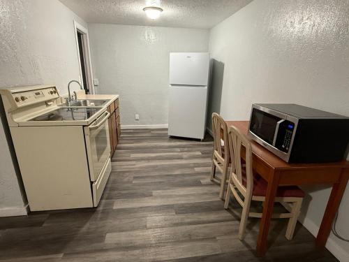 a kitchen with a refrigerator and a table with a microwave at Budget Inn Bend in Bend