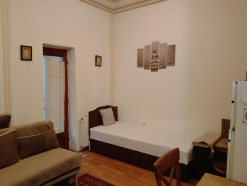 a bedroom with a bed and a couch and a chair at Tali in Novi Sad