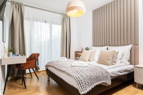 une chambre avec un lit, un bureau et une fenêtre dans l'établissement Vistula Suite l A Lovely Place to Be, à Cracovie