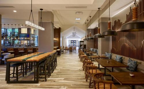 a restaurant with wooden tables and chairs and a bar at Pittsburgh Airport Marriott in Robinson Township
