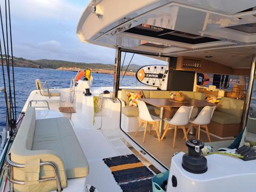 a boat with a table and chairs on the water at Dortoka Catamarán in Sitges