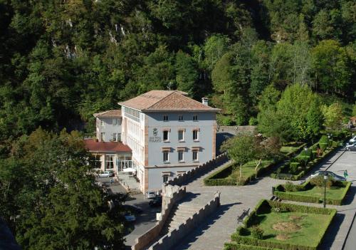 
a large building with a clock on the side of it at Arcea Gran Hotel Pelayo in Covadonga
