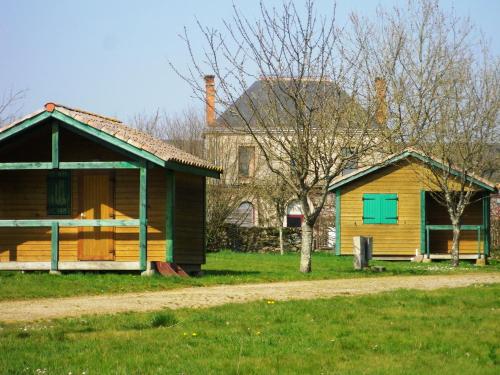 une maison et une maison avec une porte verte dans l'établissement Aire Du Verger, à Palluau