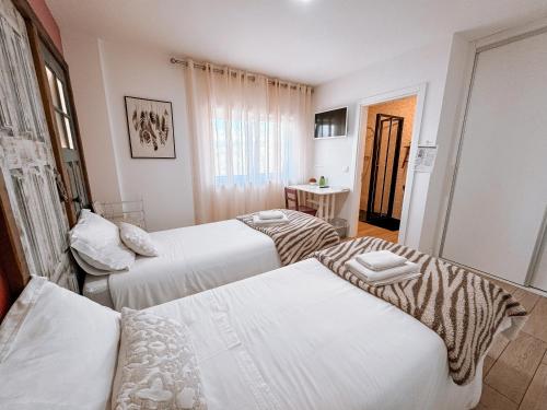 a hotel room with three beds and a window at Ninho D'Arara in Tondela