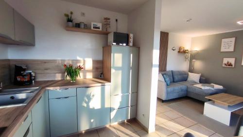 a kitchen with a refrigerator and a living room with a couch at Ferienwohnung OstseeBlick Rerik in Rerik