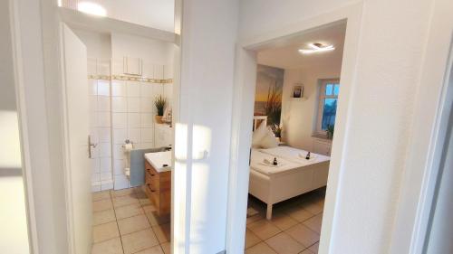 a white bathroom with a tub and a sink and a tub at Ferienwohnung OstseeBlick Rerik in Rerik