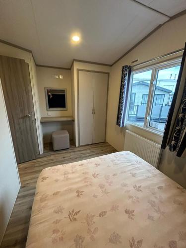 a bedroom with a large bed and a large window at 34 Brean Leisure Park Unity Beach 6 berth Passes optional No pets in Brean