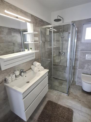 a bathroom with a white sink and a shower at Manta in Lukovo Šugarje