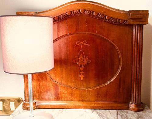 a wooden head board with a lamp on a table at Dimora del Melograno in Grezzana