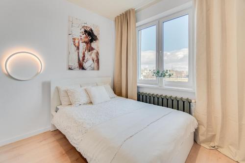 a white bedroom with a bed and a window at COMFISTAY Plac Piłsudskiego 8 - Rynek i Amfiteatr in Opole