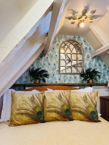 a bedroom with a bed with gold pillows at Historic Tudor Cottage, free parking, sleeps 6 and dog friendly! in Wingham