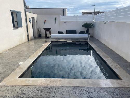 - une petite piscine d'eau dans une terrasse avec un banc dans l'établissement Serignan villa moderne avec piscine, à Sérignan