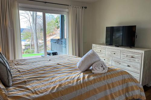 a bedroom with a bed with a television and a dresser at LakeDaze in Moneta