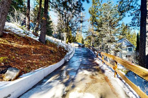 a road with snow on the ground and a fence at Whistle Stop Cabin in Lake Arrowhead