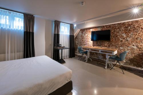 a hotel room with a bed and a desk and a tv at Boutique Hotel Oosteinde in Amsterdam