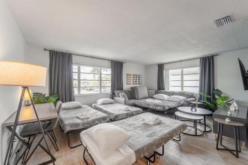 a living room with a couch and a table at Modern Chic Getaway - Sleeps 11 - Palmwavestays in Coconut Creek