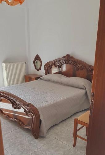 a bedroom with a wooden bed in a room at Family Vacation Home in Gjirokastër