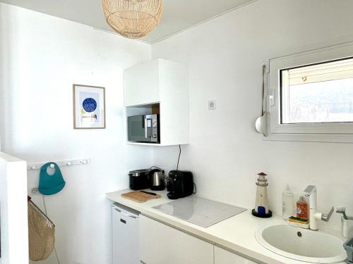 une cuisine blanche avec un évier et un micro-ondes dans l'établissement Ault Mer - Exceptional view, à Ault