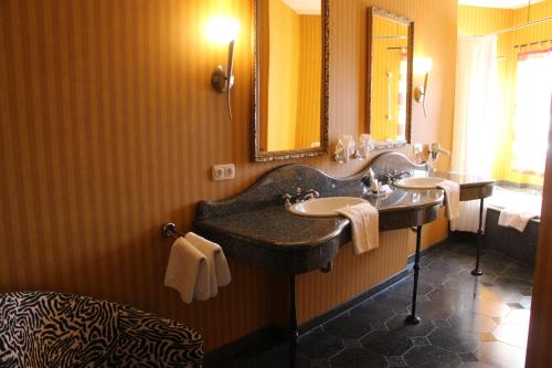 a bathroom with two sinks and a large mirror at Hotel BEI SCHUMANN in Kirschau