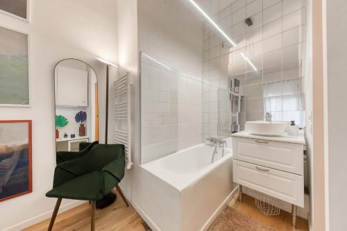 une salle de bain blanche avec une baignoire et un lavabo dans l'établissement Le Colorado - Stade de France, Aéroport CDG, Metro 13, à Saint-Denis