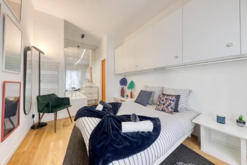 - une chambre blanche avec un lit et une chaise verte dans l'établissement Le Colorado - Stade de France, Aéroport CDG, Metro 13, à Saint-Denis