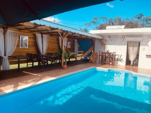 a swimming pool in front of a house at Love Guadeloupe in Sainte-Anne