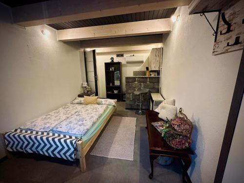 a bedroom with a bed and a table and a chair at Guszti 2 Apartman in Pécs