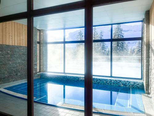 - une piscine dans une chambre dotée d'une grande fenêtre dans l'établissement Large one-bedroom apartment, wheelchair adapted, Les Terrasses d'Eos, à Flaine