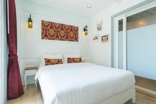a white bedroom with a white bed and a window at White Ivory Bed And Breakfast in Bangkok
