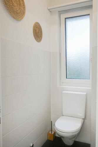 a bathroom with a toilet and a window at Enge Station - Private Room Jura in Zürich