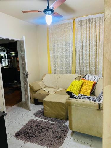 a living room with a couch and a ceiling fan at Lindo Sobrado SFS Enseada Beach in São Francisco do Sul
