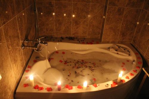 La salle de bains est pourvue d'une baignoire avec des bougies, des cœurs et des asperges. dans l'établissement Grand Alin Otel, à Turhal