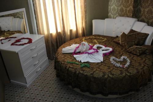 une chambre avec un lit avec des serviettes et une commode dans l'établissement Grand Alin Otel, à Turhal