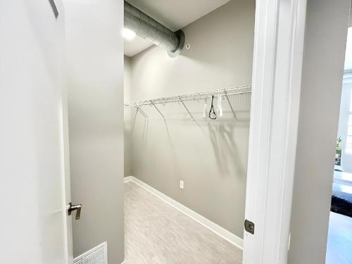 Baño blanco con ducha con puerta de cristal en Urban Oasis Downtown Condo with Skywalk Access 2, en Des Moines