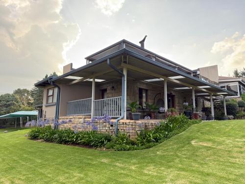a house with a green lawn in front of it at Ash River Lodge in Clarens