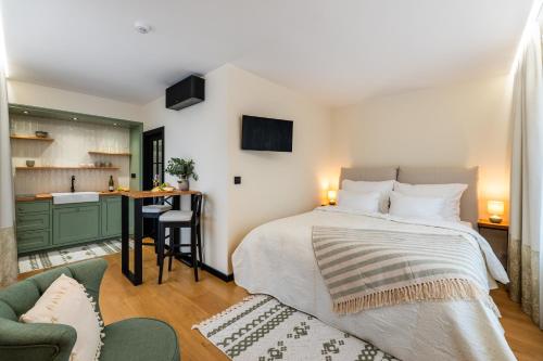 a bedroom with a large bed and a kitchen at Pinot Noir Apartments & Wine Bar in Nové Město nad Metují