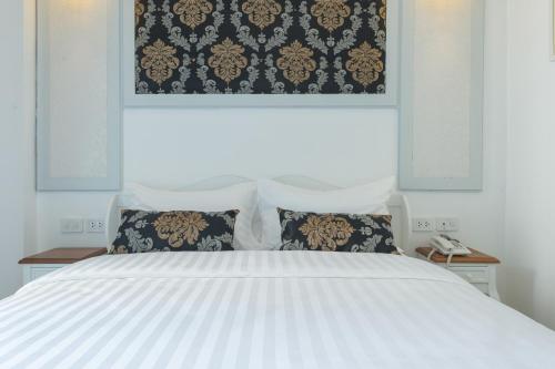 a bedroom with a white bed with two pillows at White Ivory Bed And Breakfast in Bangkok