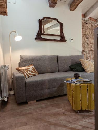 a living room with a couch and a mirror at Cal Simon- Casa a Montserrat in Collbató