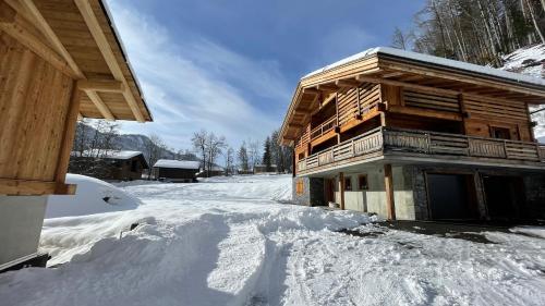 a log cabin in the snow with footprints in the snow at Chalet Birdie in Le Grand-Bornand