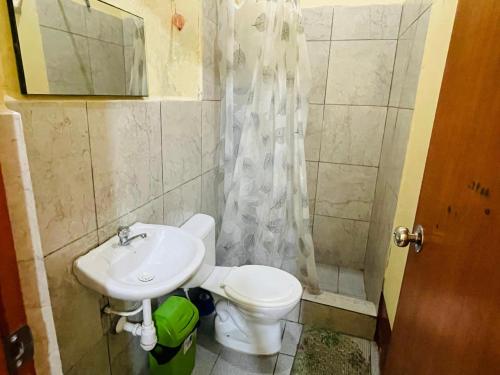 a bathroom with a toilet and a sink and a shower at Urcututo House Iquitos in Iquitos