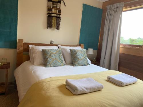 a bedroom with a bed with two towels on it at Lodge Cumbres de Chiloe in Castro